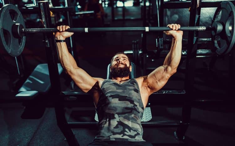 Man Doing Bench Press In Gym